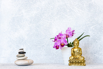 Buddha, pyramid of pebbles and orchid flower as zen background