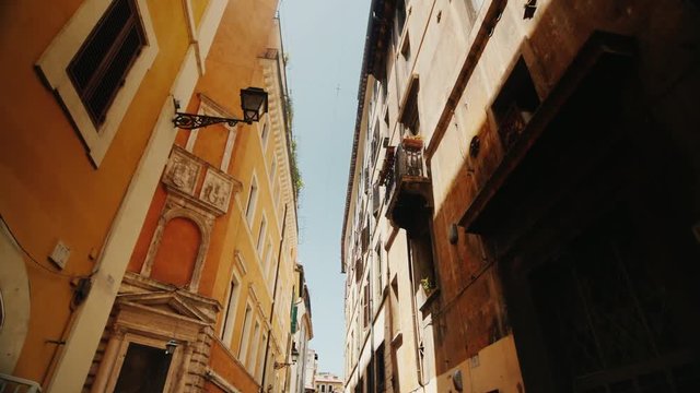 Beautiful narrow street in the old part of Rome, Italy. Medieval buildings covered with ivy. Steadicam wide lens shot