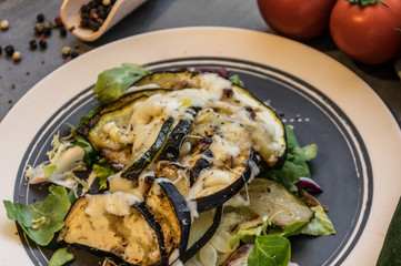 Baked zucchini and eggplant on ice salad sprinkled with cheese