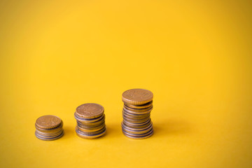 Stack of coins on a orange or yellow background