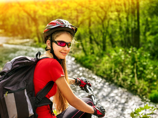 Bikes bicyclist girl rides bicycle into mountains. Woman on your vehicle in mountaineering. Female carries her bike over rocks. Bicyclist looks at his feet. Teenager in a school trip.