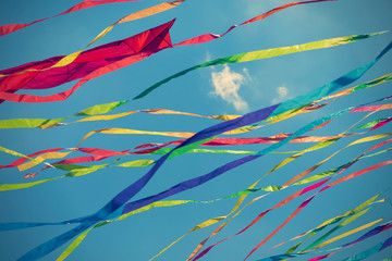 Colorful ribbons on blue sky background