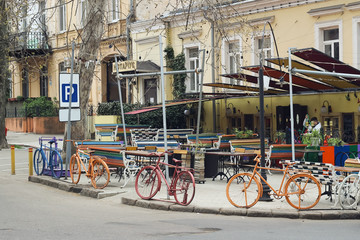 Creative metal fence of painted frames of old bicycles near a cafe in Odessa. Fashion design European modern Odessa street. Food area at street