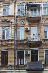 Fototapeta na wymiar Facade of an old house with three balconies in Odessa. Old facade, windows, balconies, columns. Architectural detail.