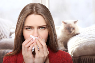 Young ill woman with tissue on white background