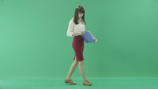 Girl stops to have a look at a blue folder she holds