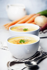 Vegetable cream soup in bowl over grey concrete background