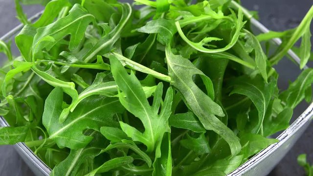 Portion of Arugula Salad rotating on a wooden plate (not loopale; 4K)