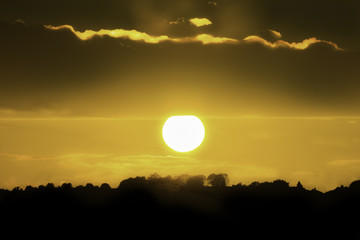 Sun setting on the horizon casting a orange glow