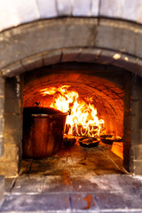 Working a real Russian oven in which the food is cooked and lit the fire.