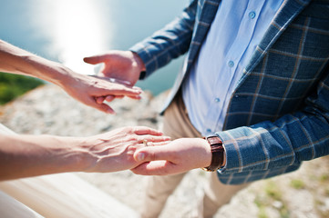 Obraz premium Handsome groom holding his wife's hands on their wedding day.