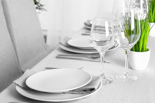 Beautiful table setting with green plant and grey napkins