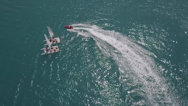hydrocycle rides around the catamaran in the Black sea viewing from drone in slow motion