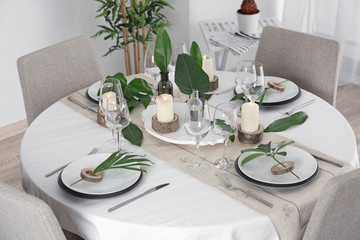 Beautiful table setting with green tropical leaves