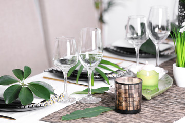 Beautiful table setting with green tropical leaves