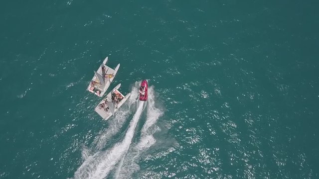 hydrocycle rides around the catamaran in the Black sea viewing from drone in slow motion