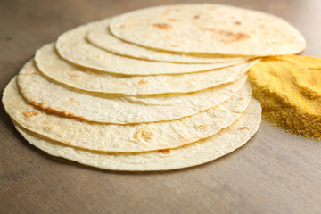 Composition with unleavened tortillas and corn flour on grey background