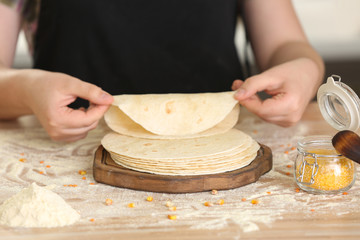 Chef cooking delicious unleavened tortillas on wooden table