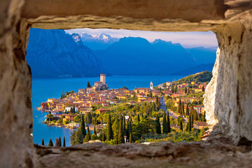 Malcesine and Lago di Garda aerial view through stone window - obrazy, fototapety, plakaty