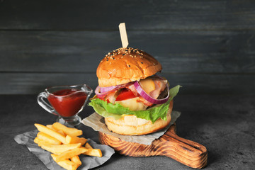 Tasty homemade burger with fries and ketchup on table