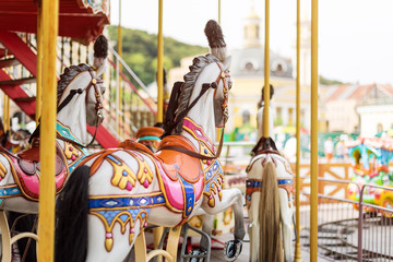 Horses on a carnival Merry Go Round. Old French carousel in a holiday park. Big roundabout at fair...
