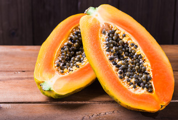 Papaya fruit on dark wood background copy space.