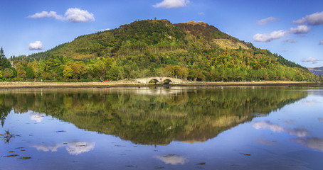 Fototapeta na wymiar Bridge reflected in a Scottish Loch.