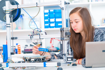 Schoolgirl prints 3d model from plastic on 3d printer