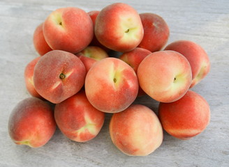 tas de pêches blanches sur fond bois,