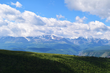 Fototapeta na wymiar White peaks of North-Chuysky ridge and green meadows of Kurai steppe in Altai mountains. Altay Region, Siberia, Russia.