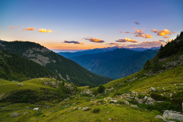 Colorful sunlight on the majestic mountain peaks, woodland and valleys of the Italian French Alps.
