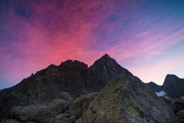 Fototapeta na wymiar Colorful sky beyond rocky mountain peak on the Italian Alps at dusk.