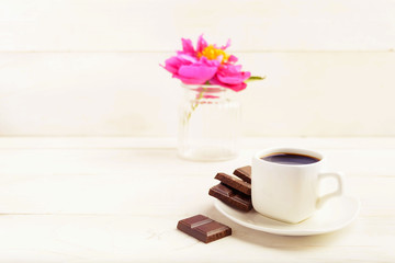 Fototapeta na wymiar A cup of coffee with chocolate and one flower in vase on white background