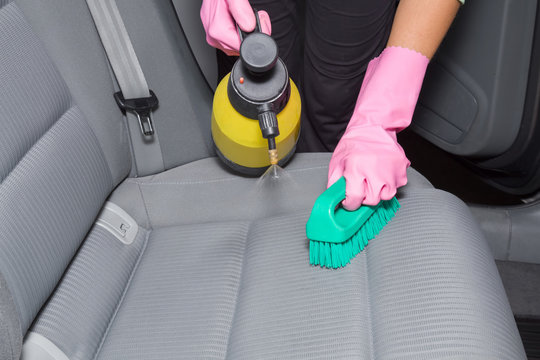 Chemical spray and brush on the car interior textile seats. Early spring cleaning or regular clean up. Professionally chemical cleaning.