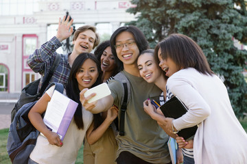 Multiethnic group of young happy students make selfie