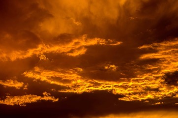 Fototapeta na wymiar Beautiful and intense sunset with cloudy orange sky