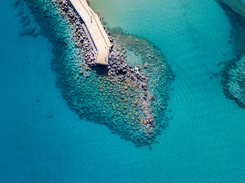 Vista aerea di un molo con rocce e scogli sul mare. Molo di Pizzo Calabro panoramica vista dall&rsquo;alto. Estate mare e turismo sulle coste calabre del sud Italia. Calabria, Italia