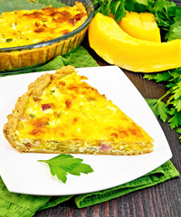 Quiche with pumpkin and bacon in plate on board