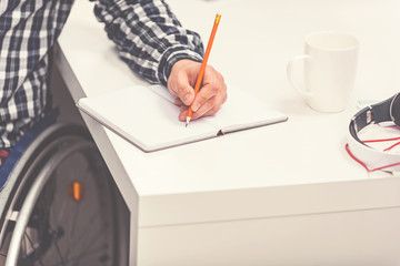 Invalid man using pencil while writing