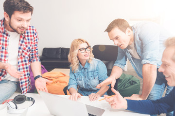 Obraz premium Positive colleagues using laptop in the office