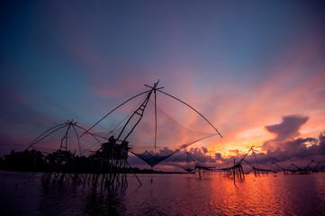 Fototapeta na wymiar Beautiful landscape of sunrise and Yor building is traditional local fisherman used net fishing in Pakpra Thale Noi, Phatthalung, South of THAILAND.