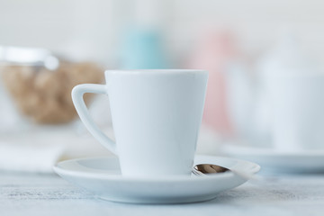 cup of coffee on table and blurred candles on background