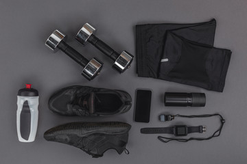 flat lay with sportswear, fitness equipment and gadgets isolated on grey