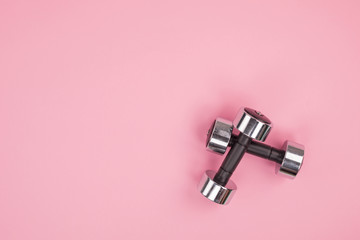 Fototapeta na wymiar top view of metal dumbbells for weightlifting isolated on pink background