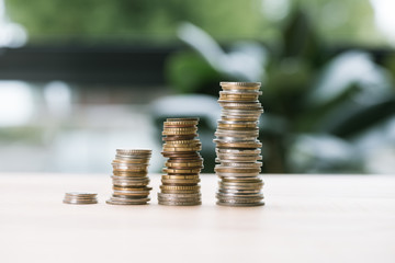 Selective focus of low and high stacks of coins on table