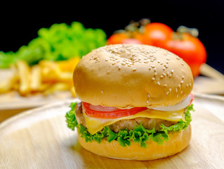 Burger on wooden plate with french fries