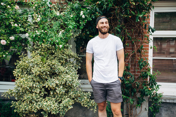 Hipster handsome male model with beard  wearing white blank  t-shirt with space for your logo or...