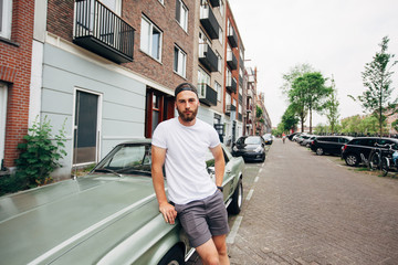 Hipster handsome male model with beard  wearing white blank  t-shirt with space for your logo or...