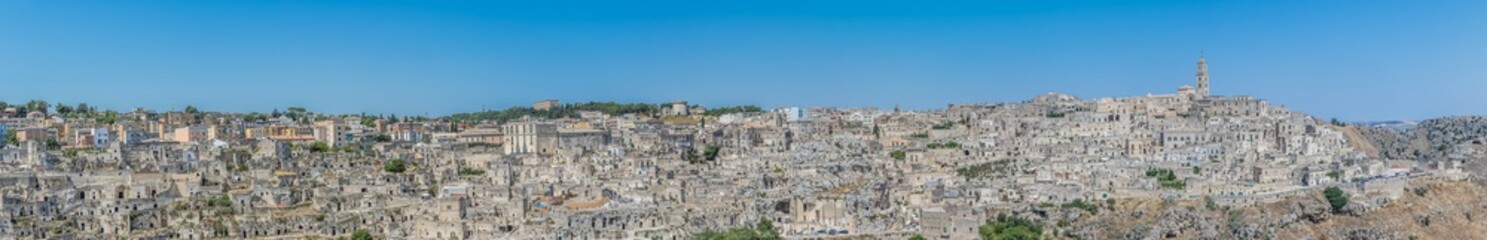 panoramic view of typical stones (Sassi di Matera) and church of Matera UNESCO European Capital of Culture 2019 under blue sky. Basilicata