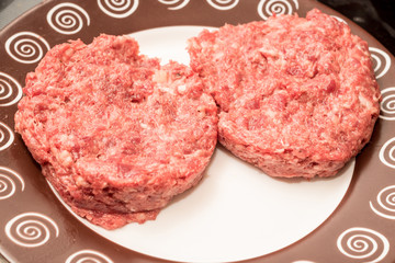 Fresh raw beef burger patties on plate